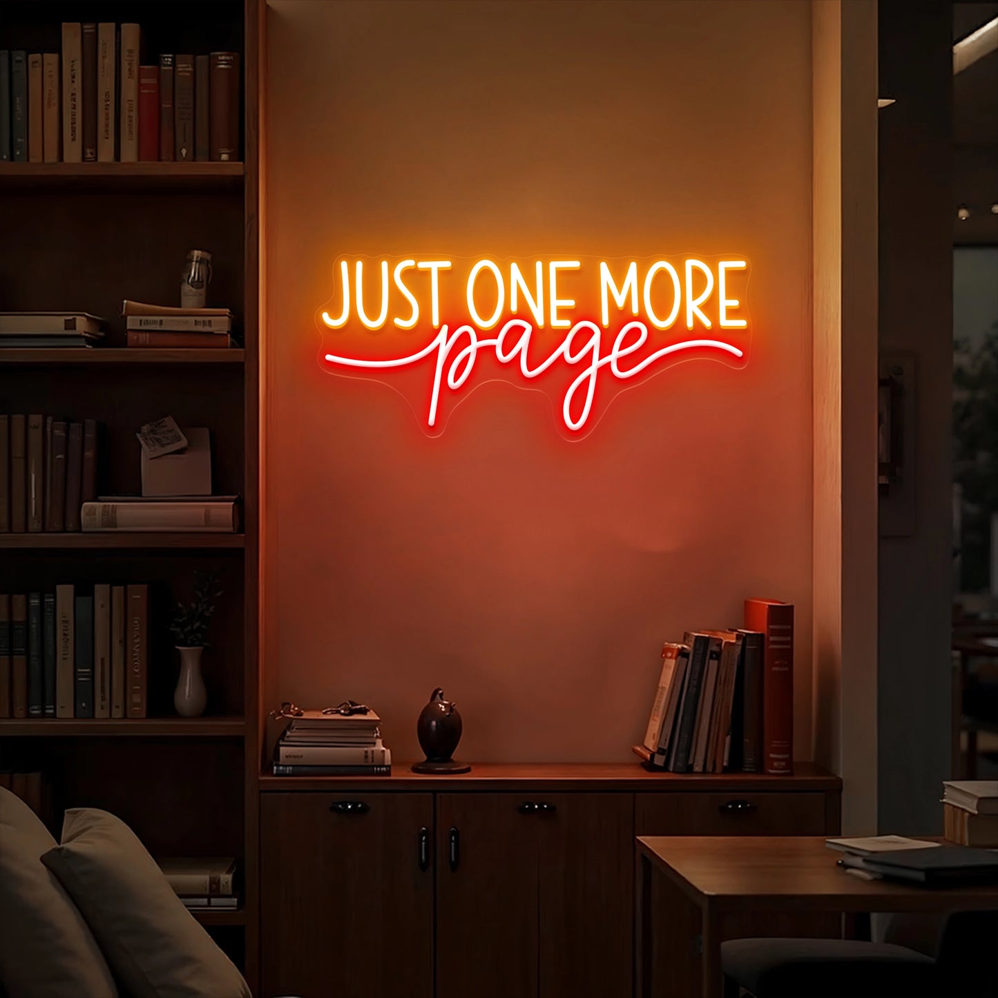 Just One More Page neon sign glowing warm white and yellow on a wooden bookshelf in a cozy home library