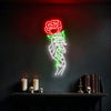 Skeleton hand holding a red rose neon sign glowing on a dark wall above gothic shelf decor